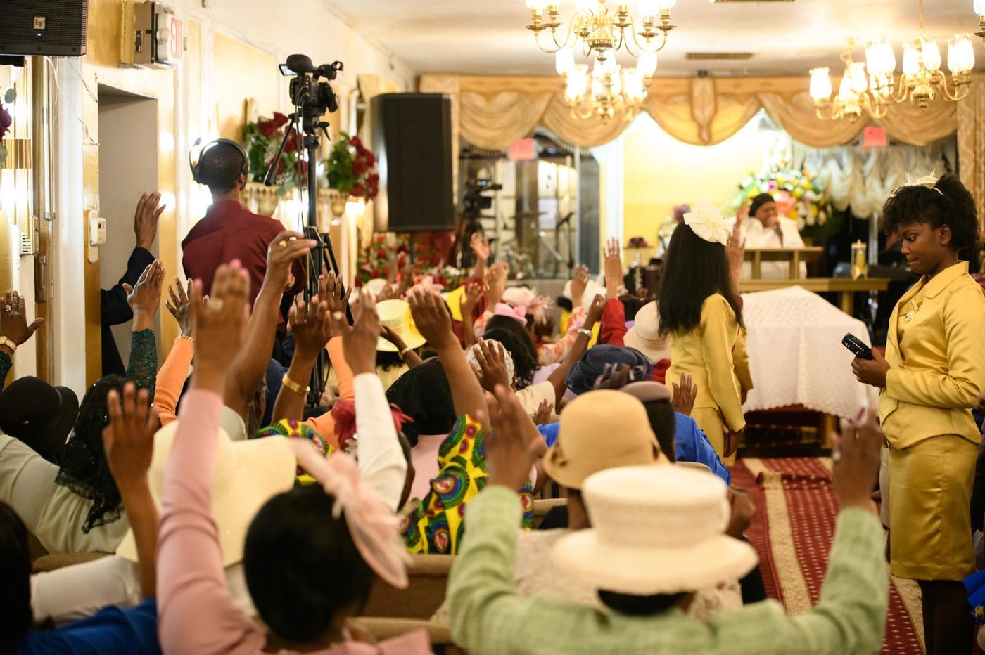 Members of the church worshipping together with hands raised